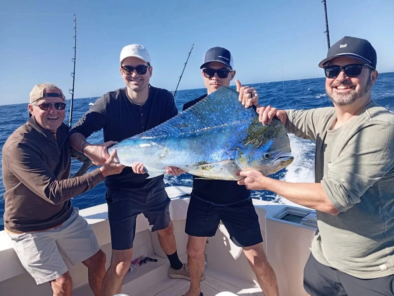 Four friends with a dorado, February 2026
