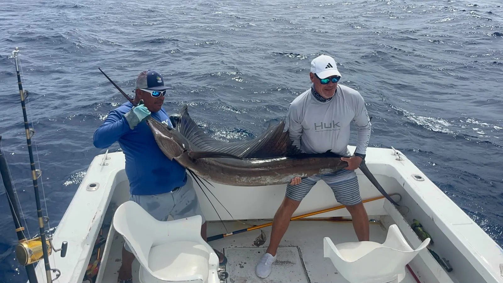 Two anglers with a sailfish on the deck, October 2026