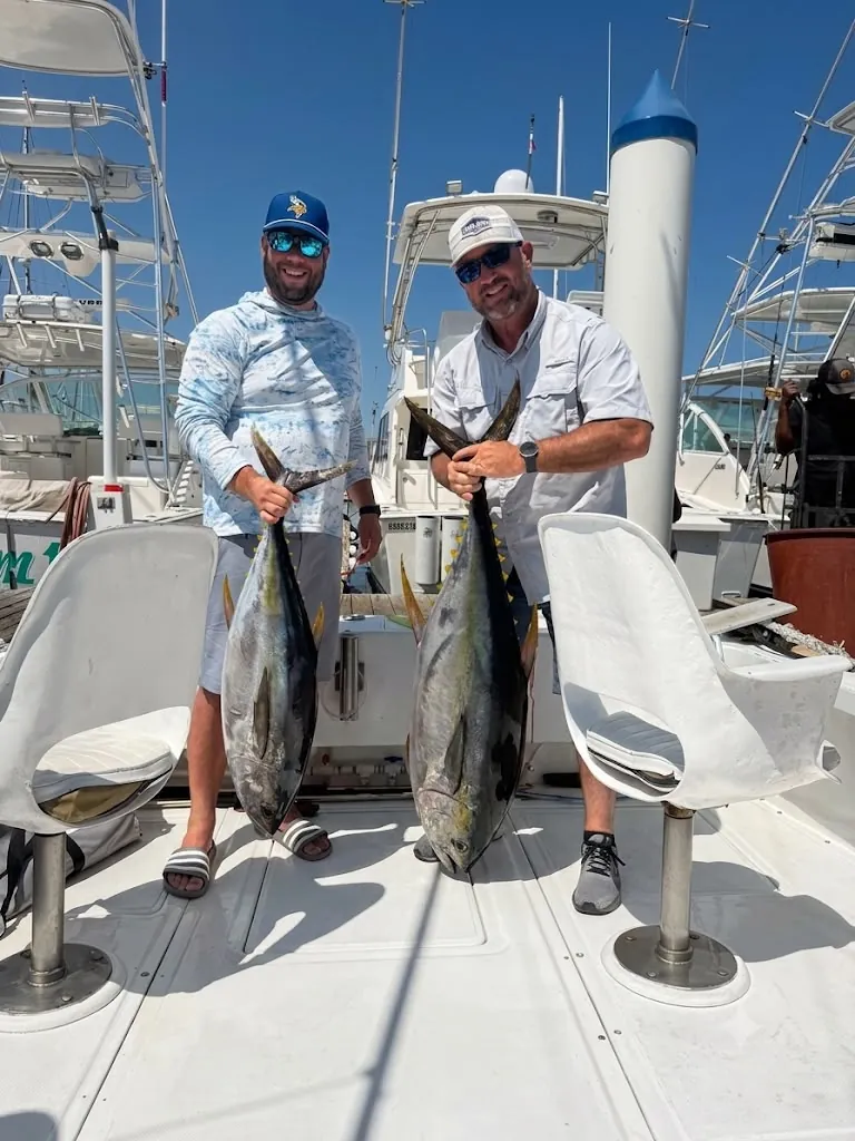 Two anglers with yellowfin tuna back at the marina, late June 2026