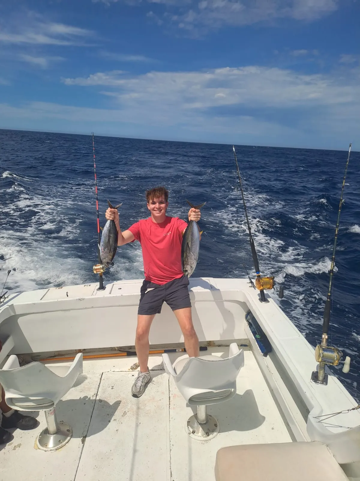 Young angler with two small tunas, late June 2026